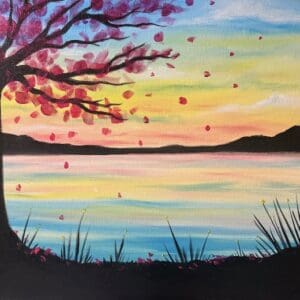 Cherry blossom tree by colorful lakeside sunset