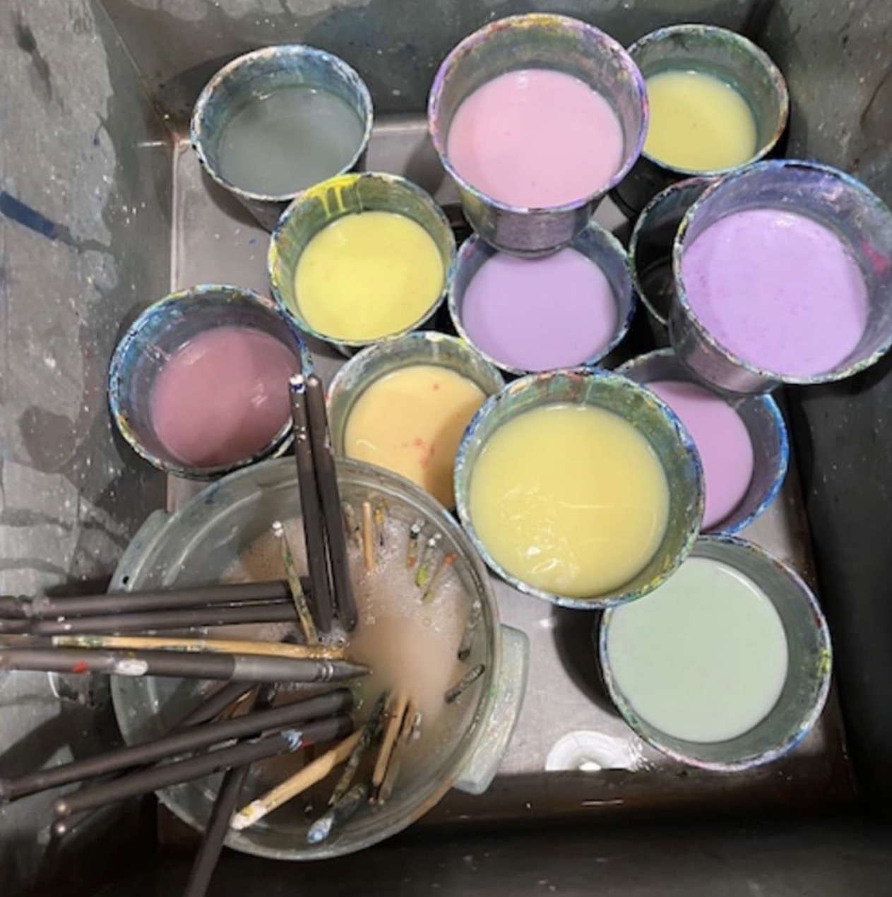 Pastel paint cups and brushes in sink